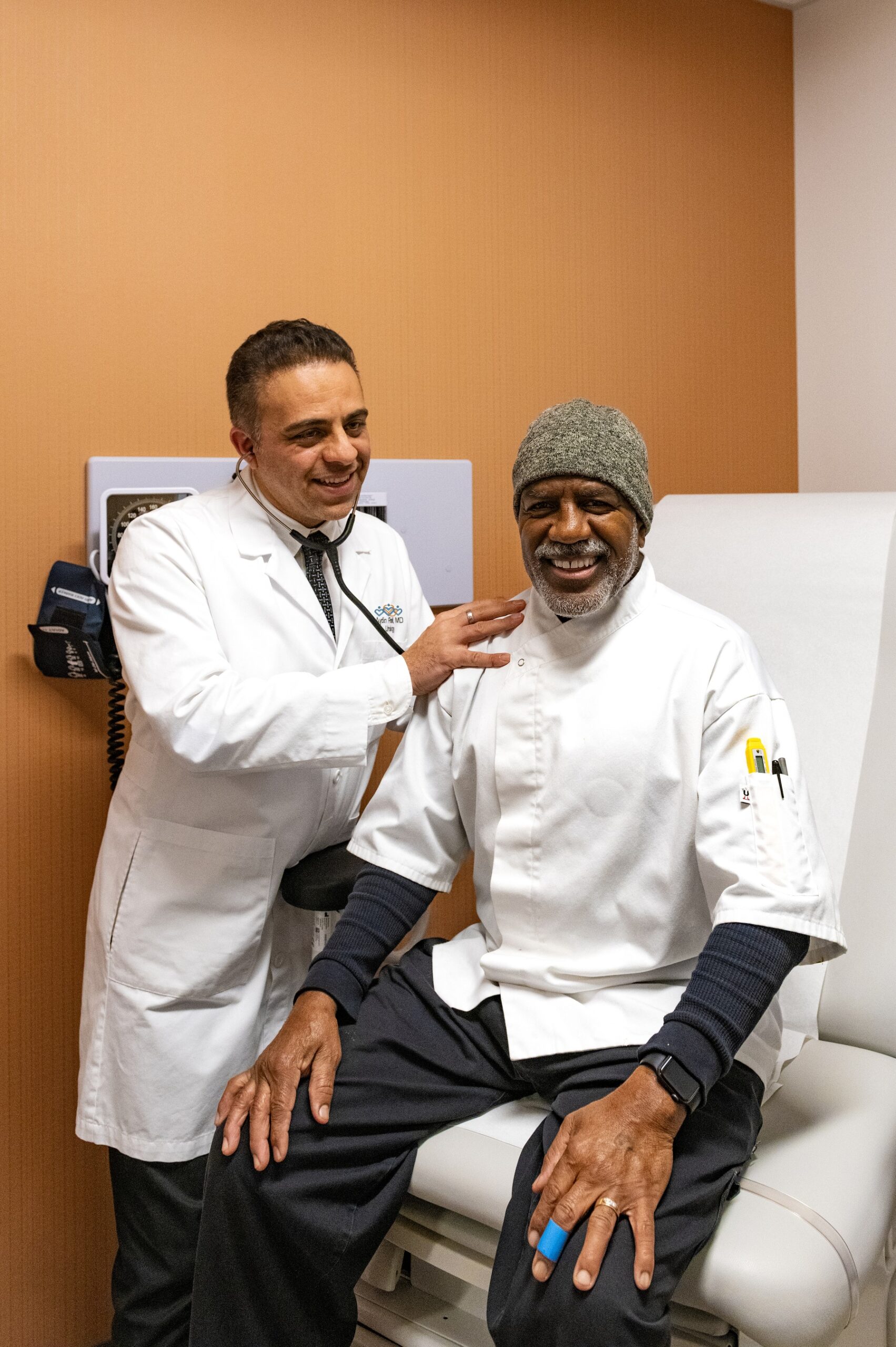 Dr. Aydin Pooli with a smiling patient in the exam room