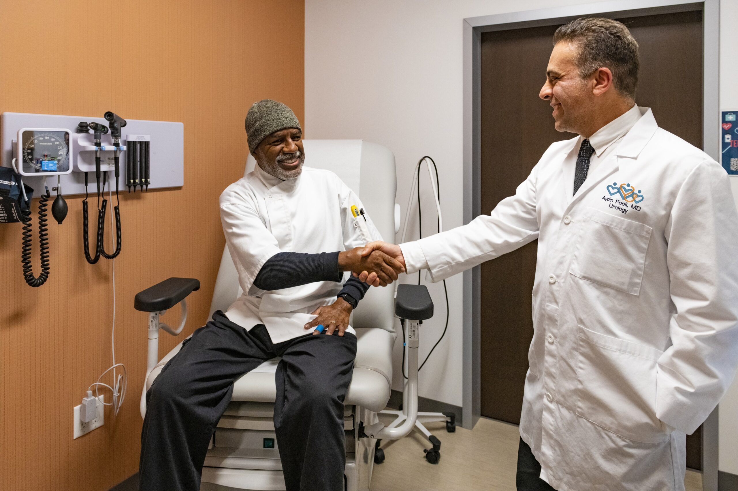 Dr. Aydin Pooli greeting a patient in the exam room