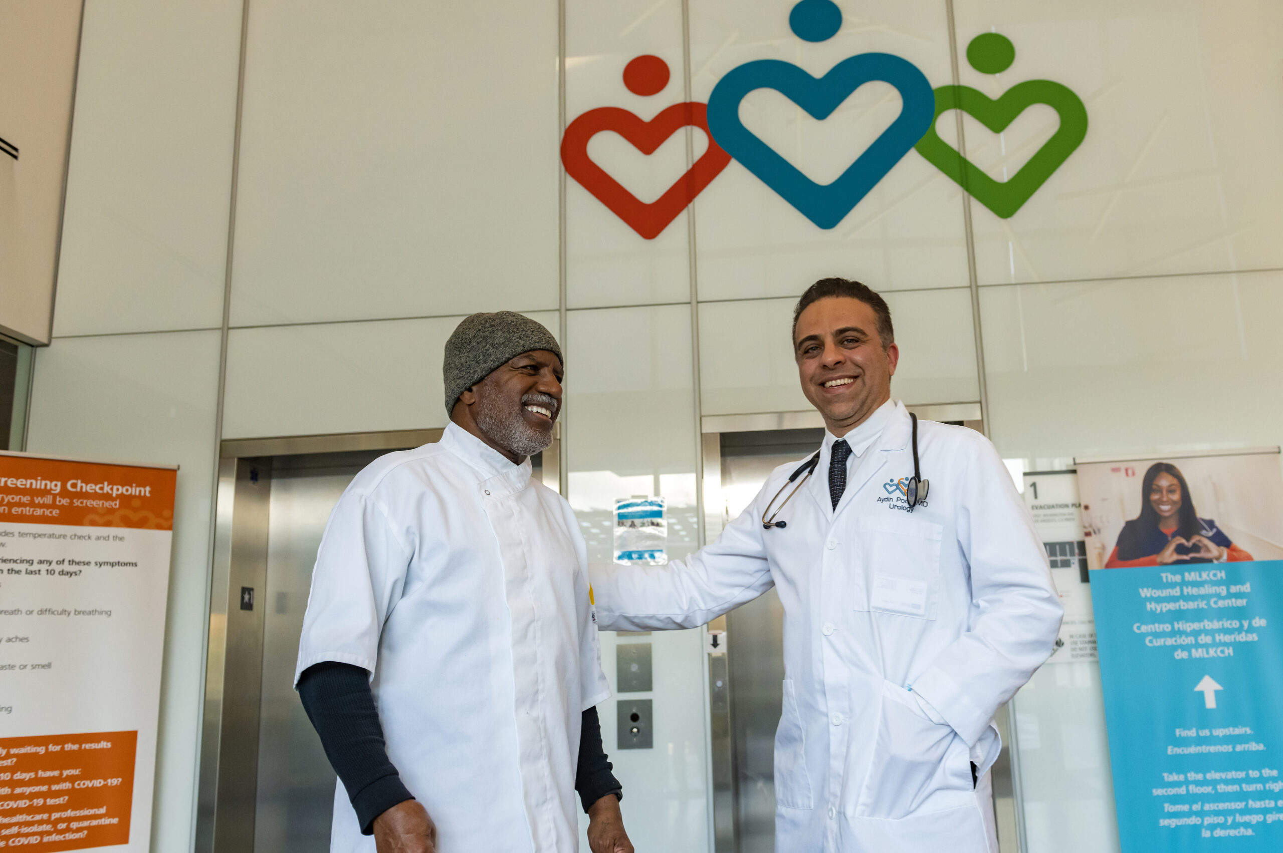 Dr. Aydin Pooli with a patient at the entrance of MLK Community Hospital