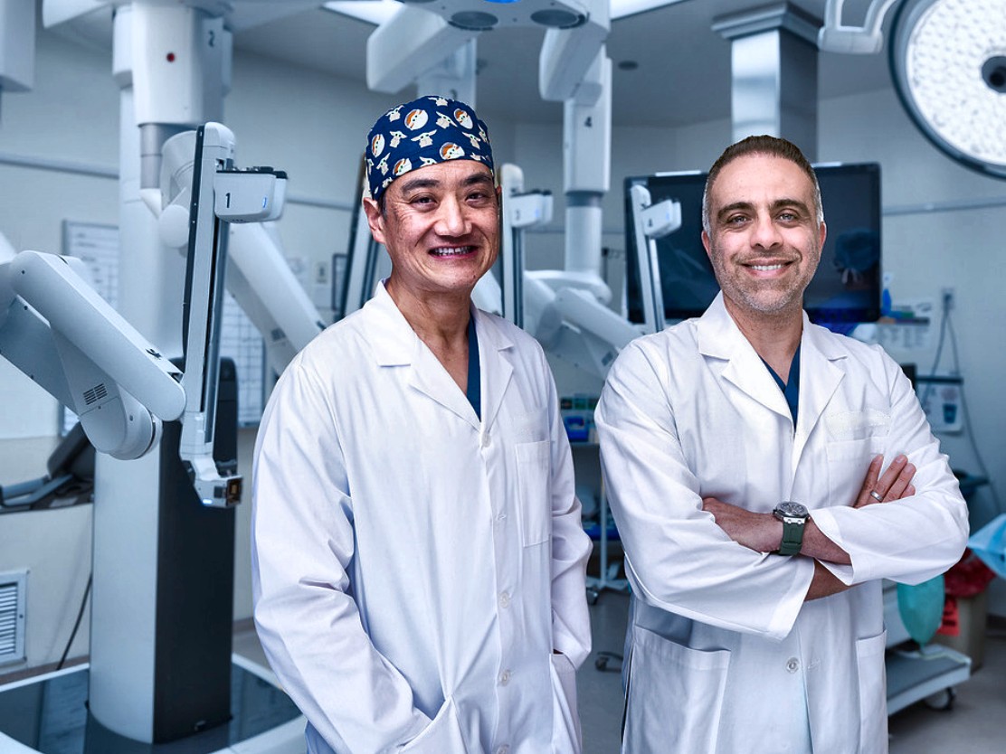 Dr. Aydin Pooli and a surgical colleague in the operating room with the da Vinci robotic surgical system